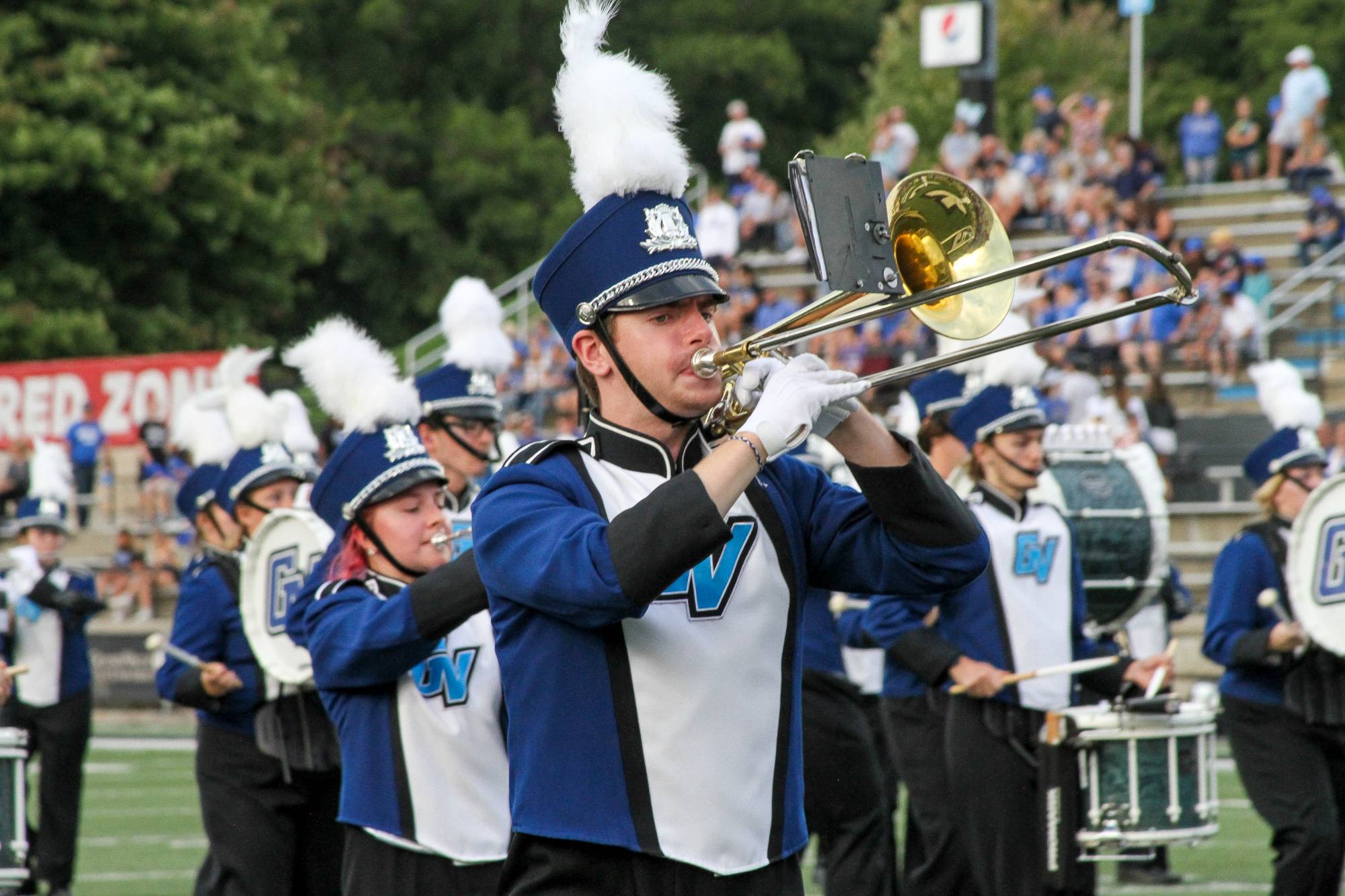 LMB member playing their trombone while in uniform at a football game